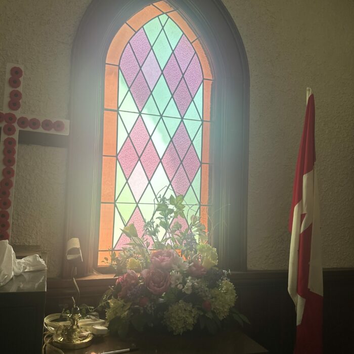 Colour photo of a stained glass window. The glass is pink, green and red