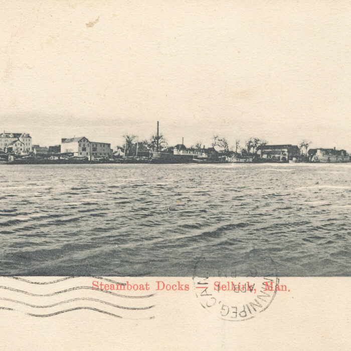 Steamboat Docks, 1949, Cathy Deleske Black and white photo of the river with boats and buildings on the shore.