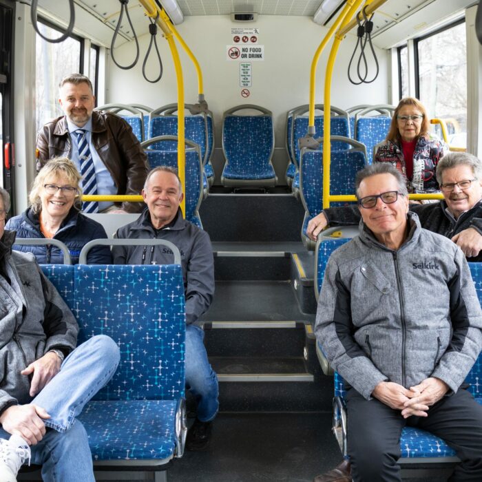 Colour image of the interior of a bus. Town council members sit on the bus