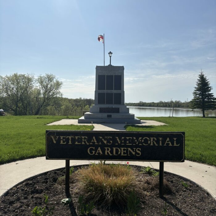 Colour photo of the veterans memorial park cenotaph, pathway, and gardens in the foreground