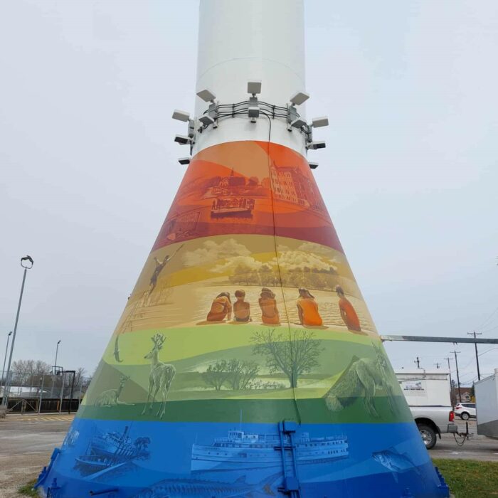 Colour photo of the base of the water tower. There are multi-coloured murals that surround the base of the tower
