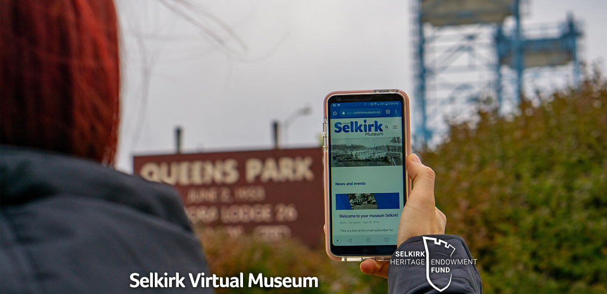 Photo of someone holding a cellphone with the City of Selkirk website page on the screen.