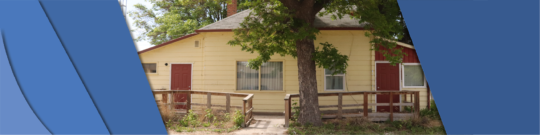 A banner of a yellow house with red doors and tree in front of it, with blue banner stripes on the sides.