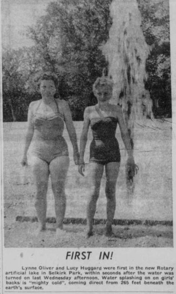 Black and white newspaper clipping of image of two women standing infront of a fountain