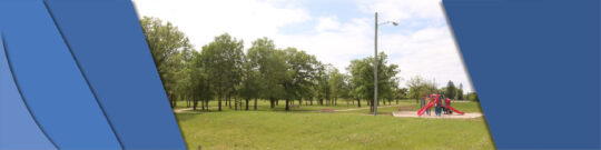 Open view of Penwarden Park. Playground and trees in sight.