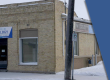 This photo shows off the single level building with a front entrance with two windows on either side