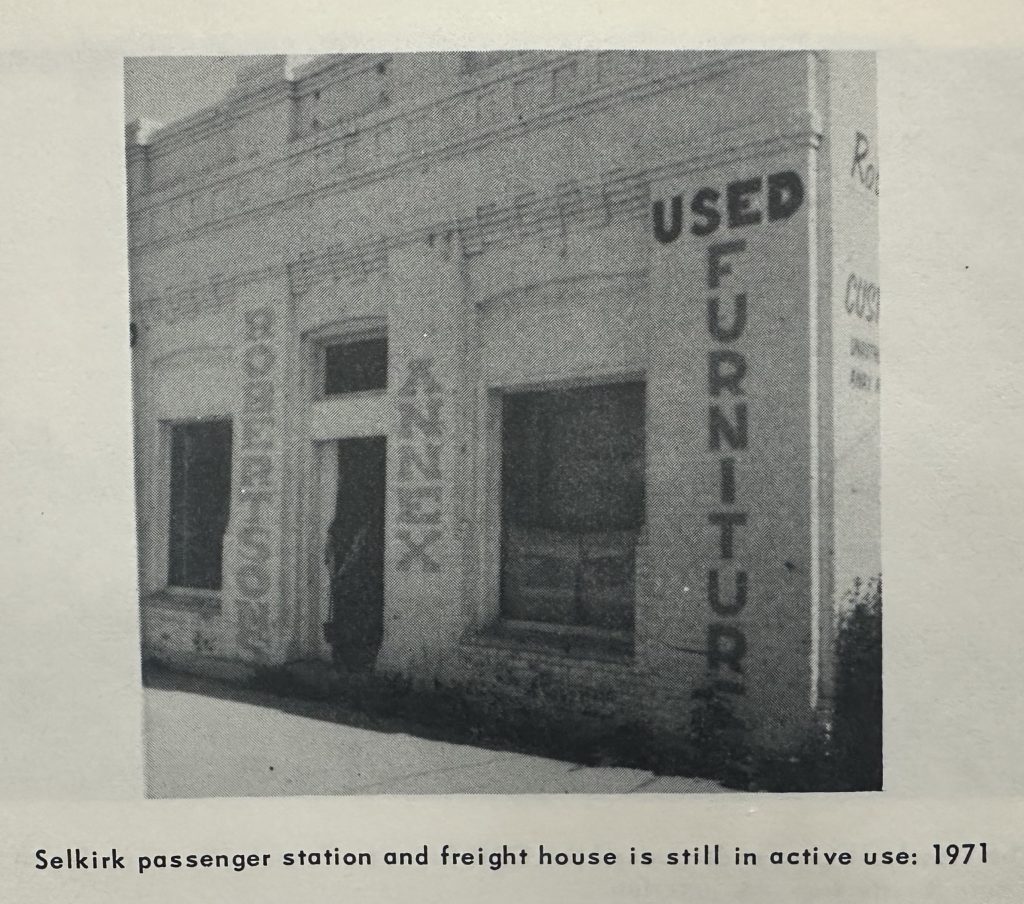 Small brick building with a door centered between two large windows. On the walls it reads 'Used Furniture' and 'Robertson Annex'