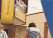 Picture of a people in front of the Garry Theatre. You can observe the featured moving sign overhang above the entrance.