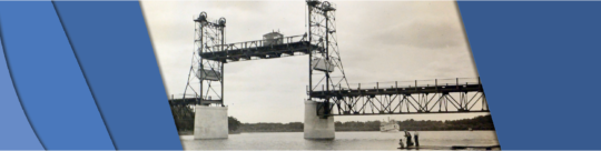 Photo showing the bridge lifted as a boat is approaching in the distance.