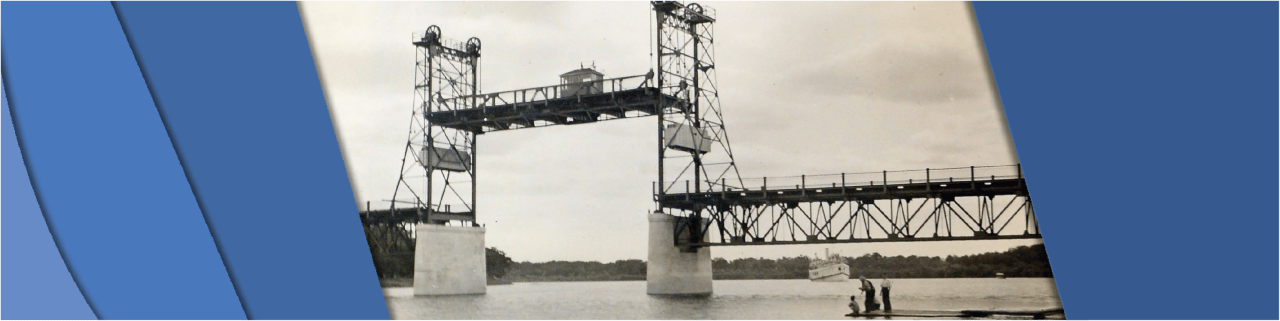 Photo showing the bridge lifted as a boat is approaching in the distance.