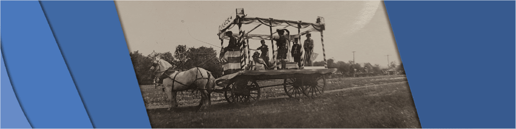 Photo showing a parade float consisting of a horse and buggy. A banner reading "Peace" is strung across it.