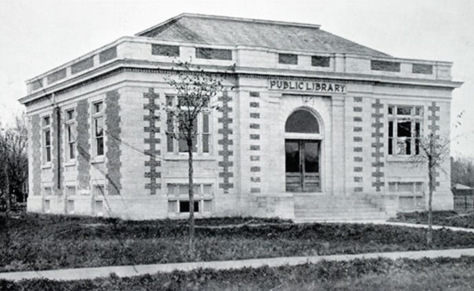 Picture of the Selkirk Library from 1913. The building is large with an arch over the front doors. Two large windows on either side of the building. Outside of the building is made with large bricks.