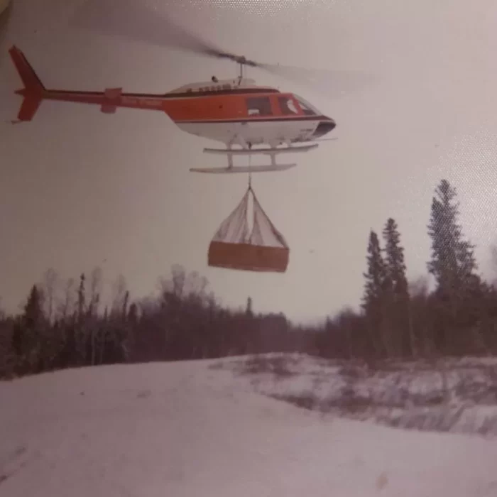 Heli Lifting a Casket at Loon Straights 2, Date Unknown, Wes Gilbart Helicopter carrying a casket in the winter