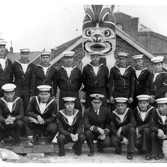 Hosaqami Totem Pole, 1960 Group of men in uniform posing in front of the Hosaqami totem pole