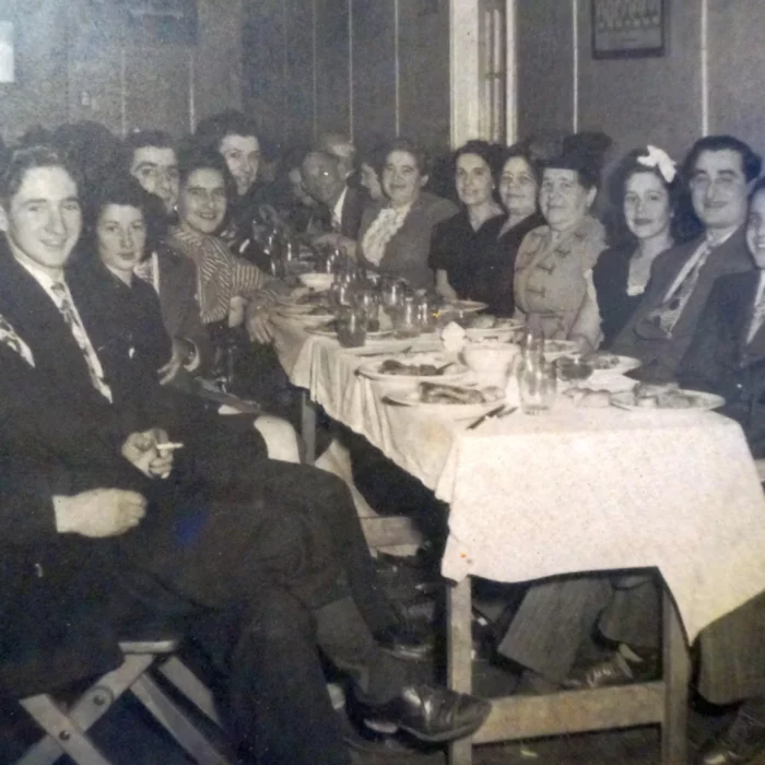 Large gathering at a dining table in black and white
