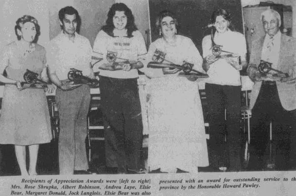 Black and white picture of a group holding awards for outstanding services