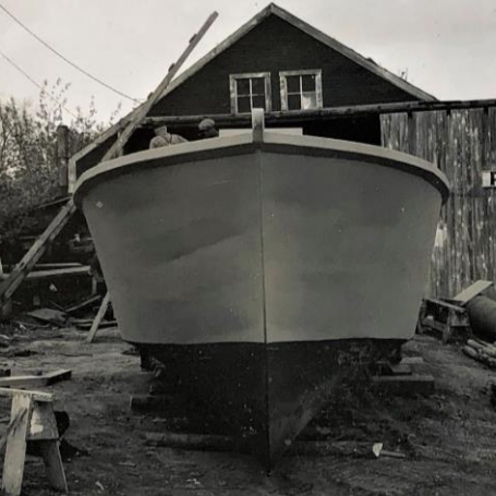 Steel Fishing Yawl at Boat Shop on Eveline, 1960s, Fraser Stewart Black and white picture of a small boat to be repaired in front of Purvis shop
