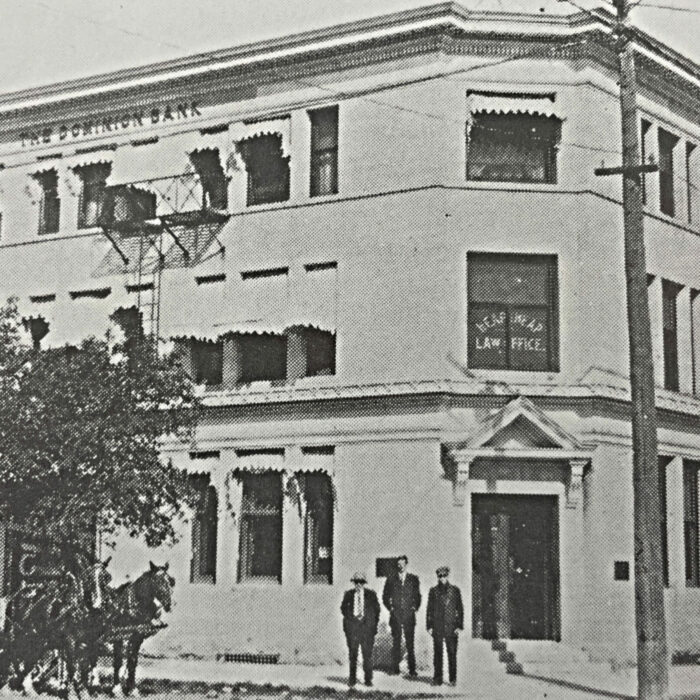 The Dominion Bank, 1913, Archives of Manitoba Black and white photo of the Dominion Bank, with 3 men in suits standing in front of the building