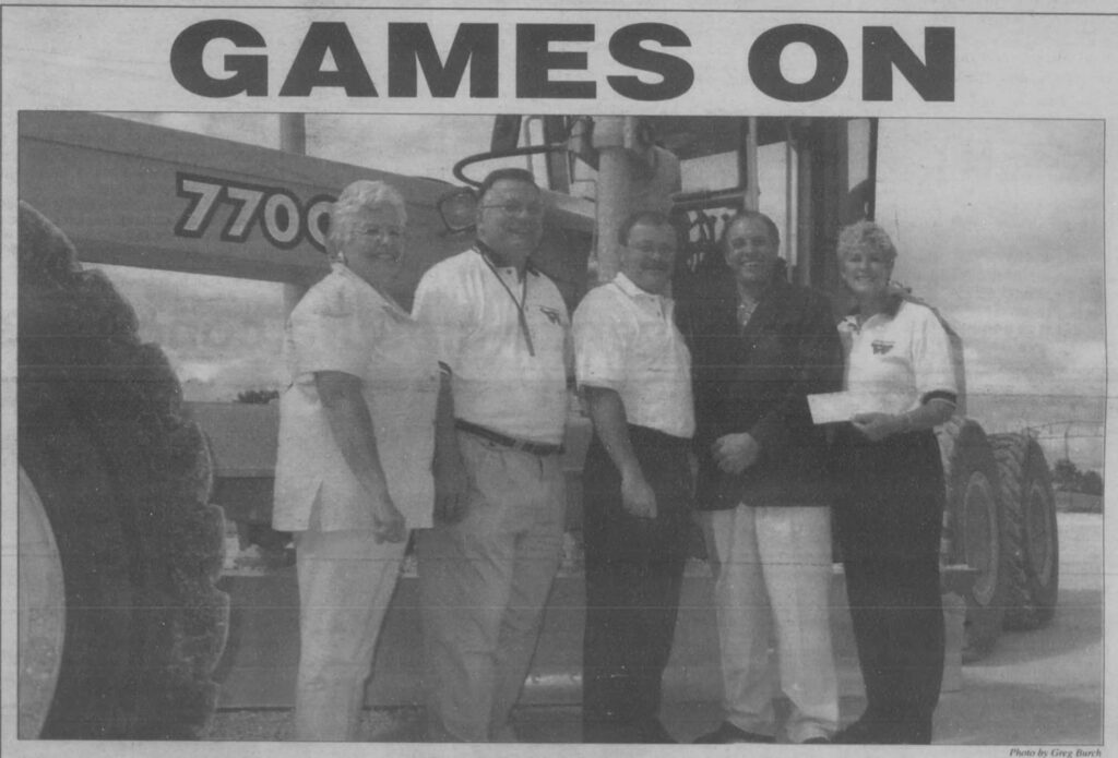 People posing in front of a tractor with the headline reading "Games On".