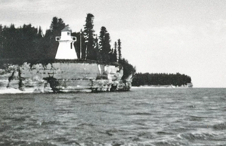 Photo of white lighthouse on a cliff.