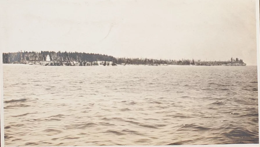 Photo of lake with lighthouse in distance.