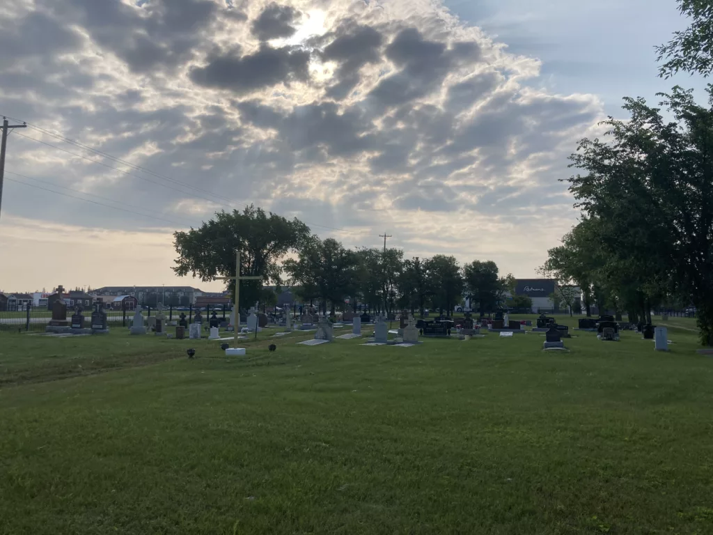 Photo of headstones in a field surrounded by a fence.