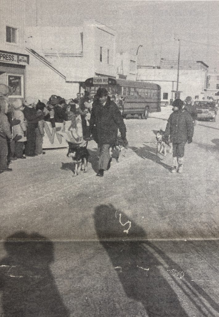 People clapping on Manitoba Ave in Selkirk as men with dogs go by