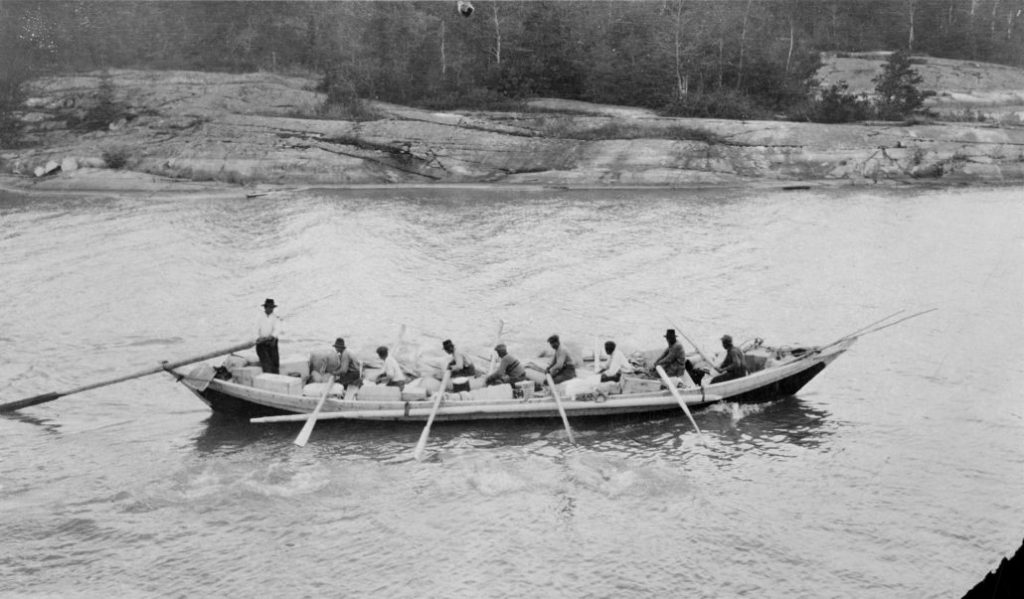Black and white photo of a group of people in a York boat.