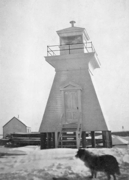 Lighthouse with a dog in front of it.