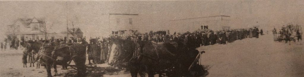 Dog races in front of Post Office as people watch over