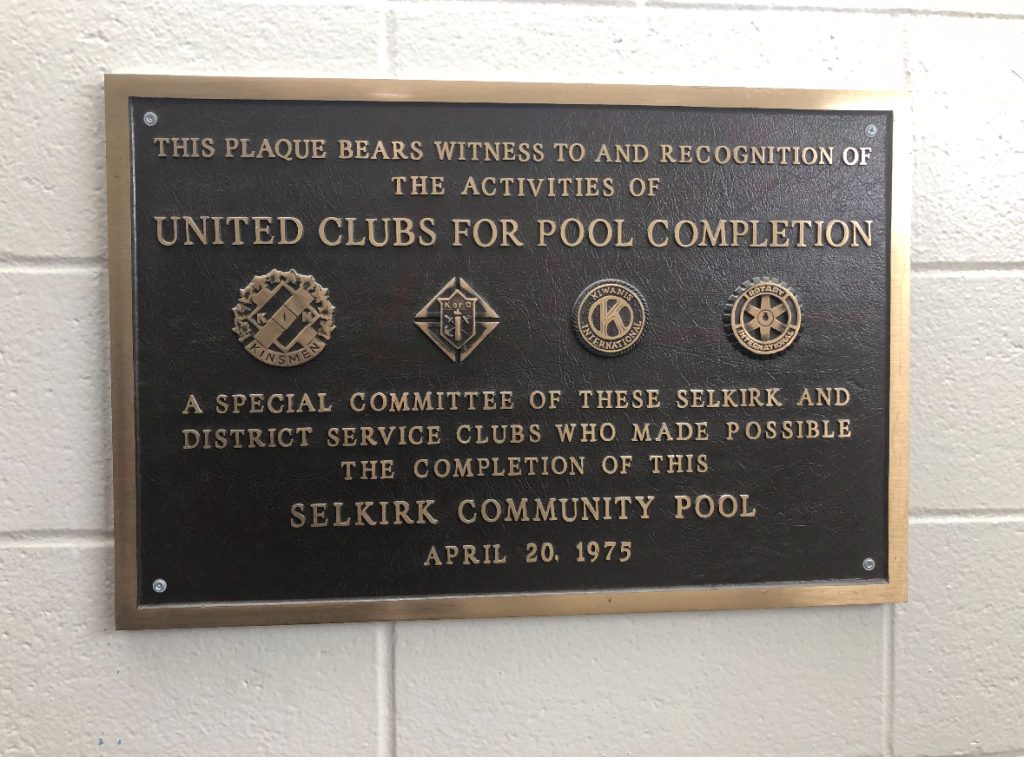 Large black framed plaque listing the names of those who contributed to building the pool