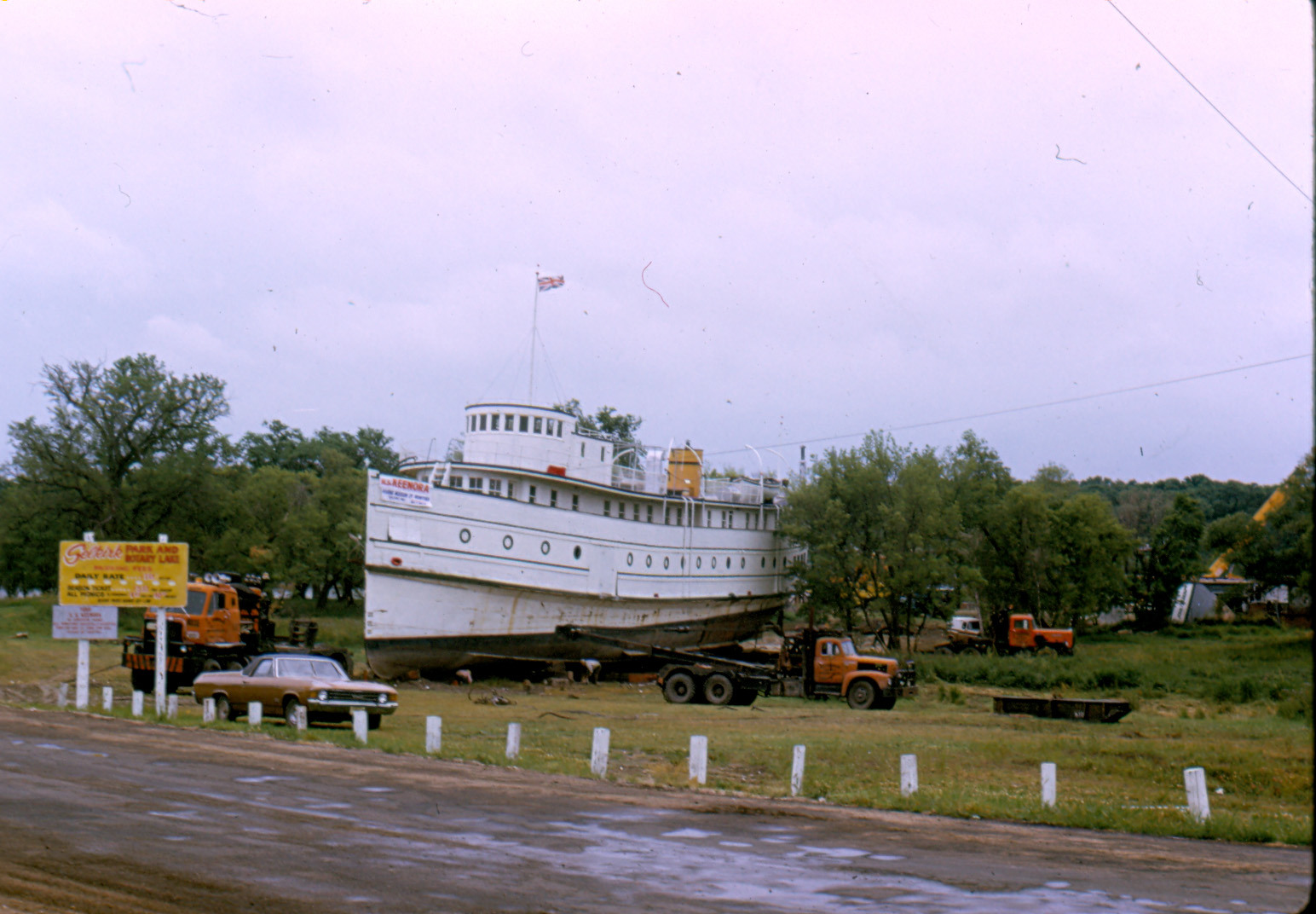 Colour photograph of the Marine Museum when the Keenora Arrived. The road at the forefront of the image is muddy and the sky overcast