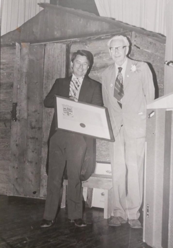 Black and white image of Mayor Bill Shead and the Earl of Selkirk posing together. Mayor Bill Shead holds the Selkirk Coat of Arms