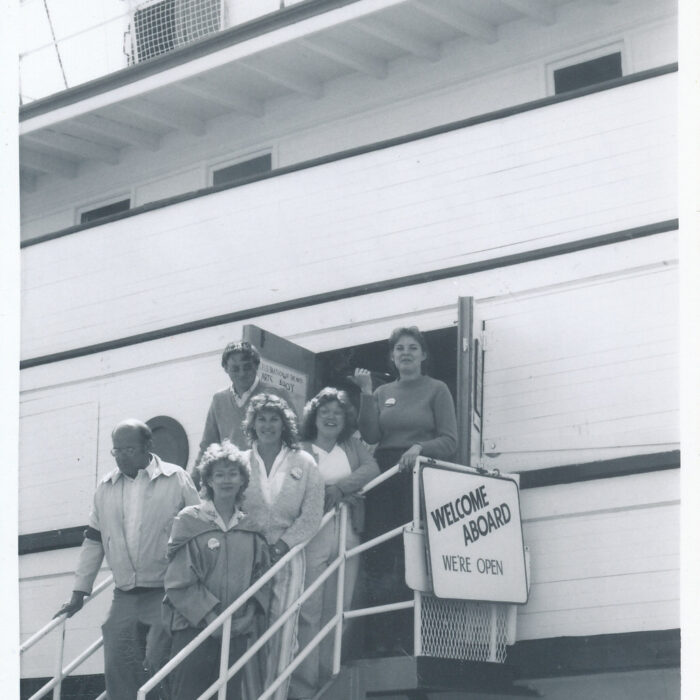 Official Opening of the Marine Museum, Wendy Johnson, Terri Starsiak, Val Goodman, Irene Horon, Bernie Wagner, Bob Davis, 1974, Selkirk Museum Black and white image of the Keenora on opening day. People stand on the staircase leading up to the door.