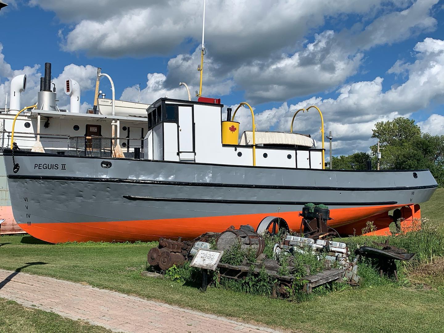 Colour photograph of the Peguis II. The boat is grey and orange, which matches the Bradbury