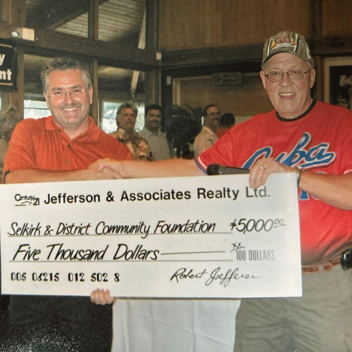 Chair Michael Buhr Receives $6000 from the Bob Jefferson & Associates Century 21 Charity Golf Tournament, 2009, Selkirk District Community Foundation Two men stand together holding an oversized cheque