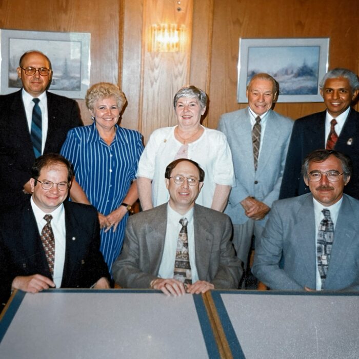 First Board of Directors, Front, Elmer Kuber, Lewis Wasel, Bill Findlater, Back, Ed Sitarz, Jean Oliver, Dawn MacFarlane, Charles Barnard, Dr. Ike Hussain, c1995, Selkirk District Community Foundation A group of people sitting and standing behind a table. The people are the first board of directors