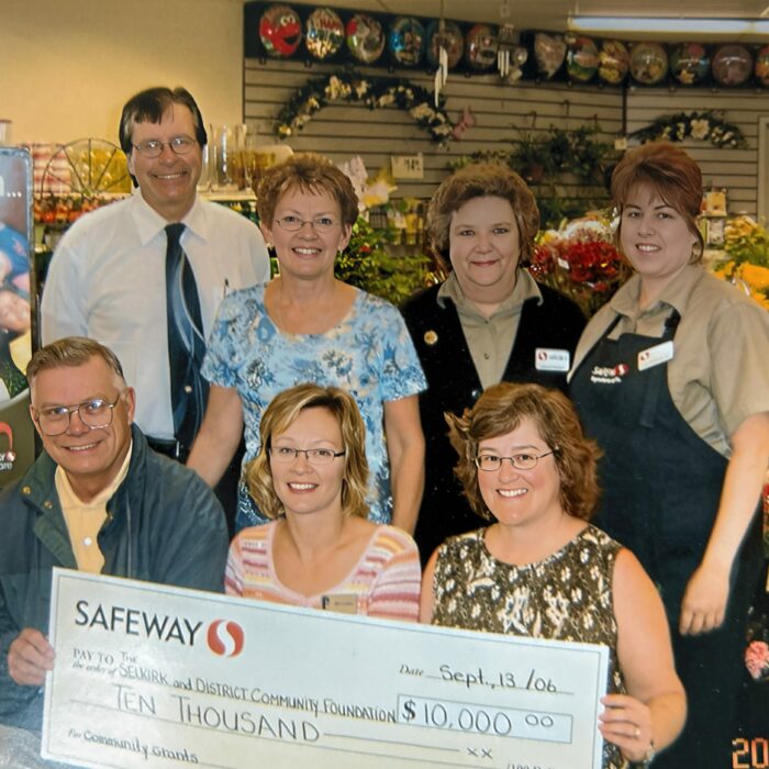 Larry Johanson, Gail Bodman, Leanne Kordalchuk, Darlene Duncan, Bud Oliver, Bev Clegg, Leslie Hanson and $10,000 Cheque From Saveway, 2006, Selkirk District Community Foundation A group of people sitting and standing around a cheque in the Selkirk Safeway