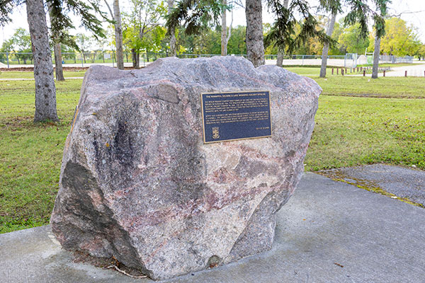 Colour image of stone monument with a black and gold plaque