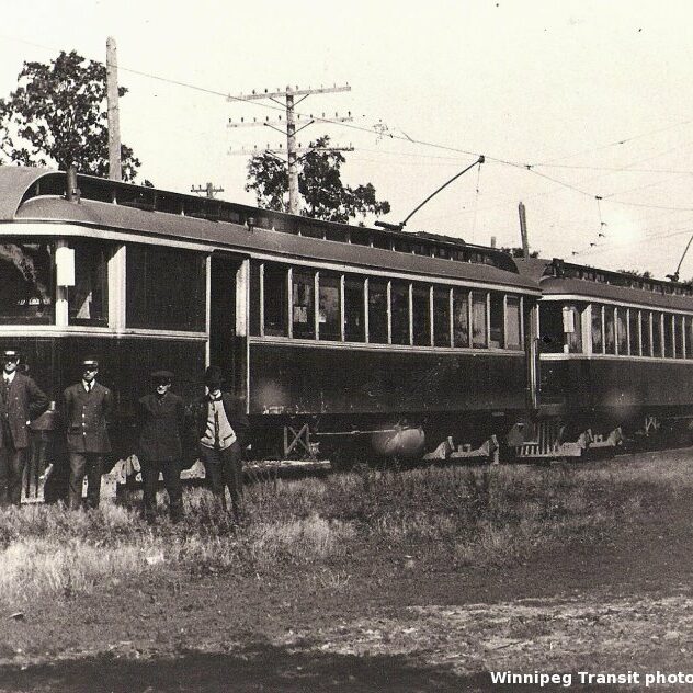 Black and white image of a street car on a track. Grass surrounds the track