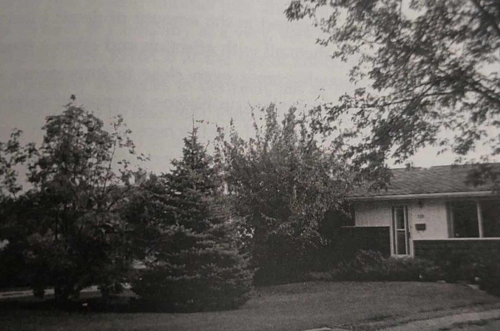 Black and white image of a house and trees