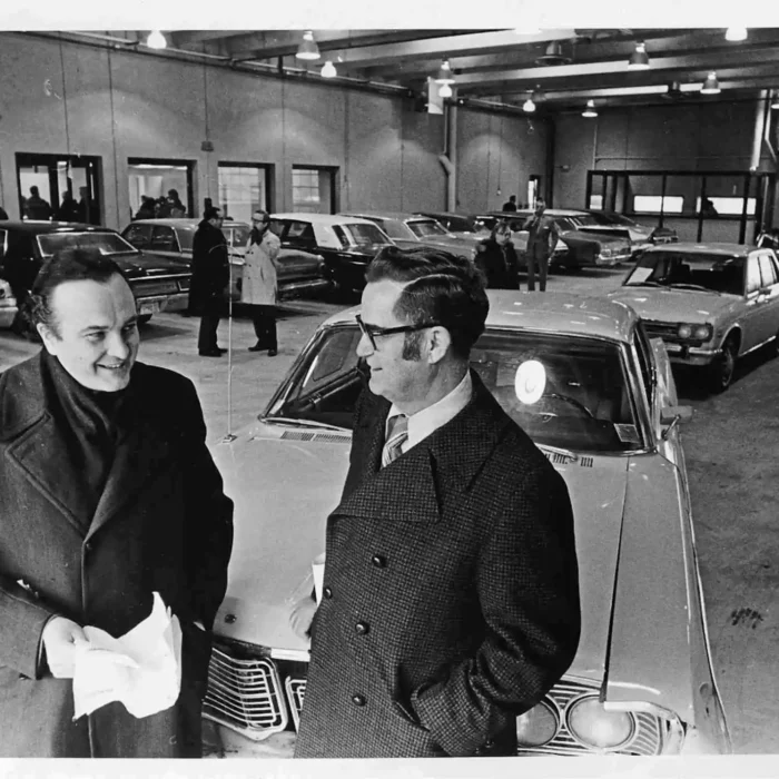 Pawley at the Opening of the First Manitoba Public Insurance Corp. Claims Centre, 1972, Winnipeg Free Press A black and white photo of Howard Pawley and another man standing inside a car garage. They are dressed in buttoned jackets