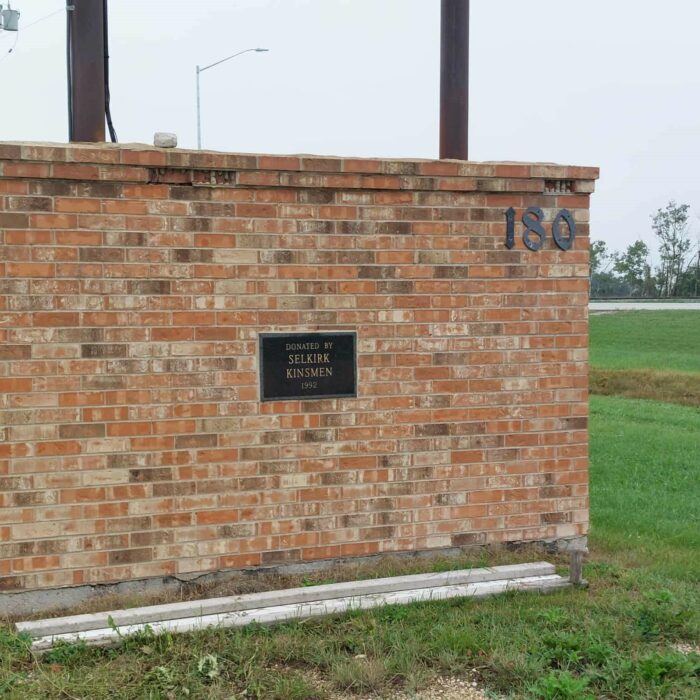 Colour photo of a brick wall with a small plaque on it