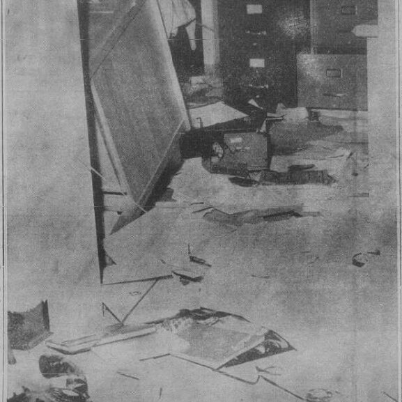 Vandalism of Robert Smith School, 1968, Selkirk Enterprise Black and white image of an office. The office desk is tipped over, there are papers on the floor and other items strewn around. There are filing cabinets in the background