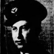 Black and white photo of a soldier looking to the left of the camera. He wears a military cap