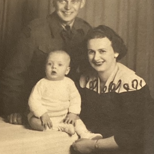 Harold, Margurite, and Six-Month-Old Jim, c1943, Icelandic Collection, Elizabeth Dafoe Library, University of Manitoba A black and white image of a young family. The mother holds her baby son in front of her and behind them both is the father. Both parents smile at the camera.