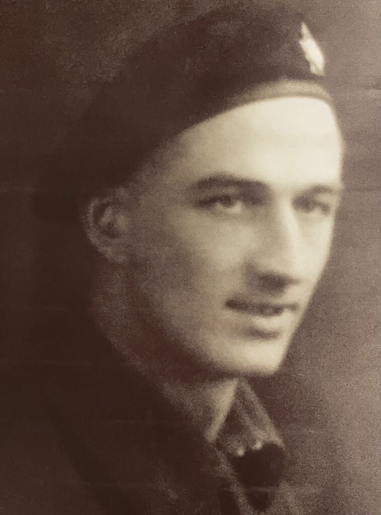 Black and white image of a man in military uniform. He is looking to the right of the camera