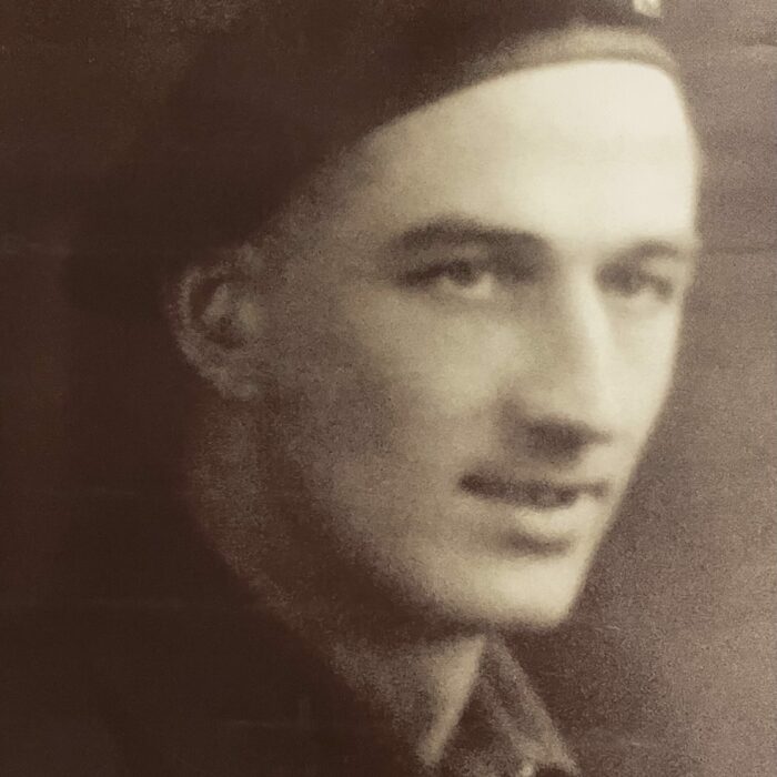 Black and white image of a man in military uniform. He is looking to the right of the camera