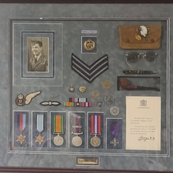Jack Norquay's War Medals and Personal Belongings, 2022, Manitoba Metis Federation A colour photo of a framed picture of military meals and badges