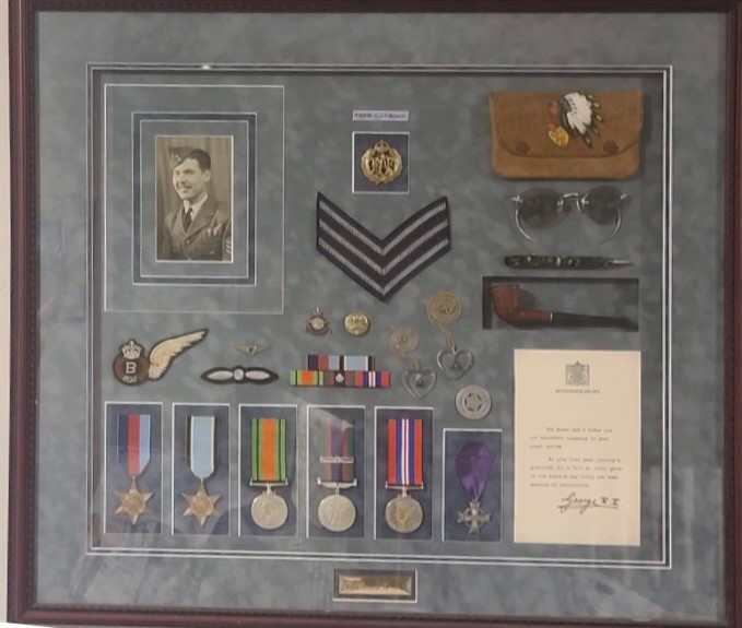 A colour photo of a framed picture of military meals and badges